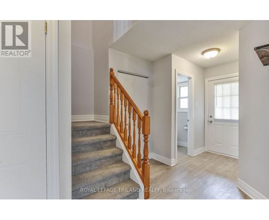 A hallway with a staircase and a door.