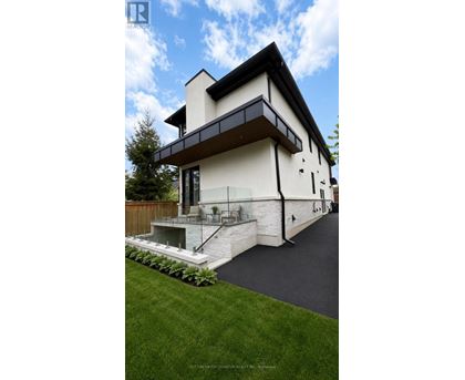 A modern house with a white exterior and a black roof.