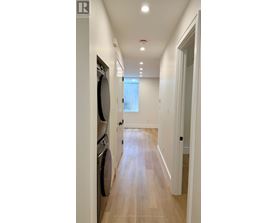A long hallway with a washer and dryer on the left.
