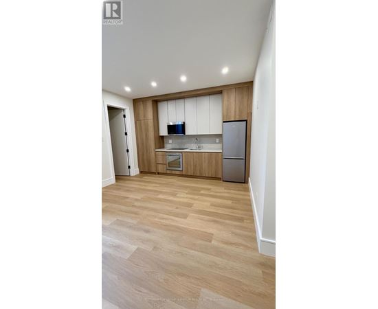 A kitchen with wooden cabinets and a refrigerator.