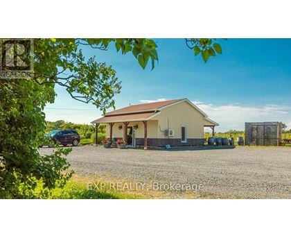 A gravel yard with a building and a car.