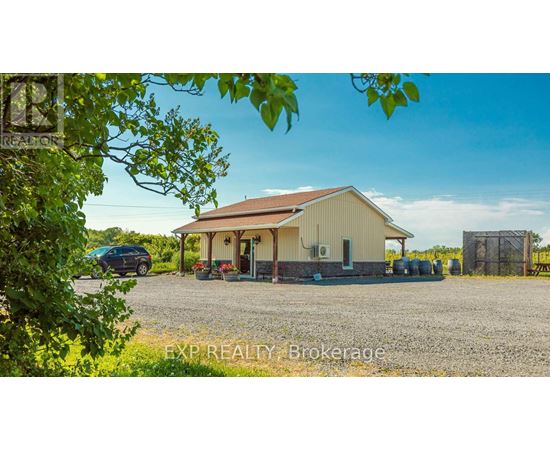 A gravel yard with a building and a car.