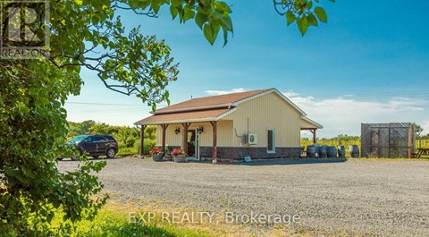 A gravel yard with a building and a car.