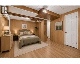 A bedroom with a bed, nightstands, and a painting on the wall.