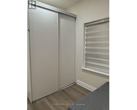 A white sliding door in a room with a grey couch.