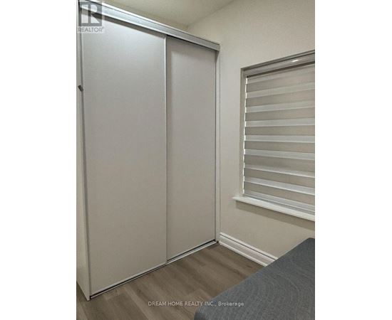 A white sliding door in a room with a grey couch.