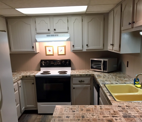 A kitchen with a black stove top oven and a black microwave.
