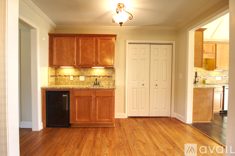 A kitchen with wooden cabinets and a black fridge.