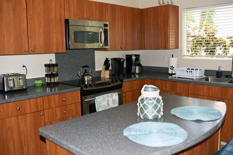 A kitchen with wooden cabinets and a microwave above the stove.