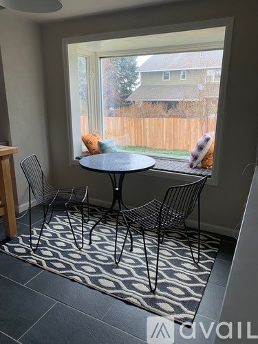 A dining room with a round table and four chairs.