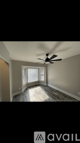 A room with a ceiling fan and a window.