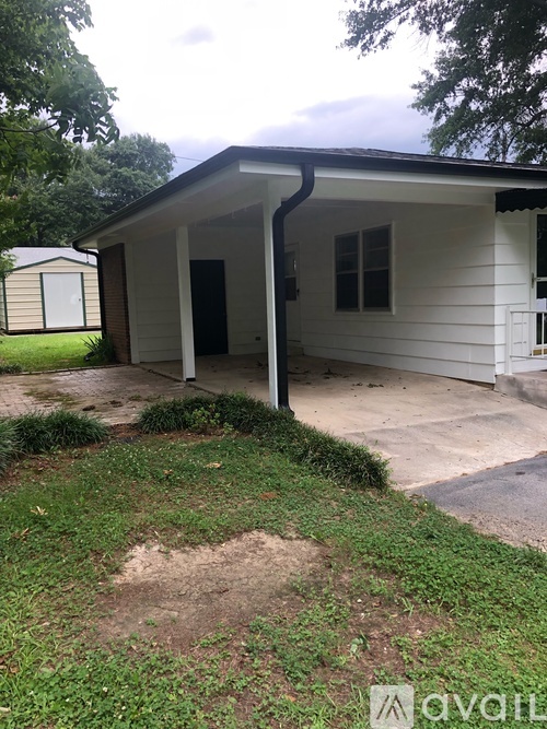 A small white house with a black roof and a small porch.