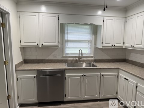 A kitchen with white cabinets and a stainless steel dishwasher.