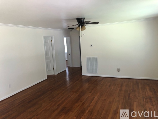 A room with wooden floors and a ceiling fan.