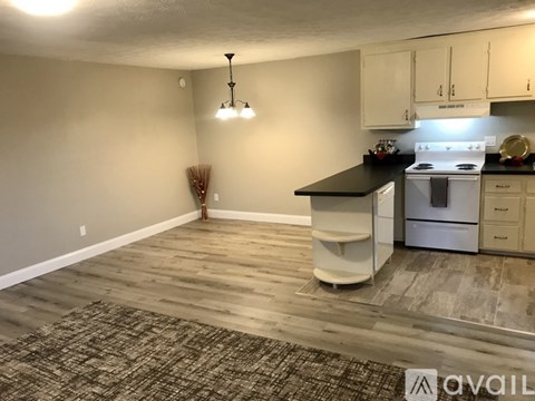 A kitchen with a white stove and black countertop.