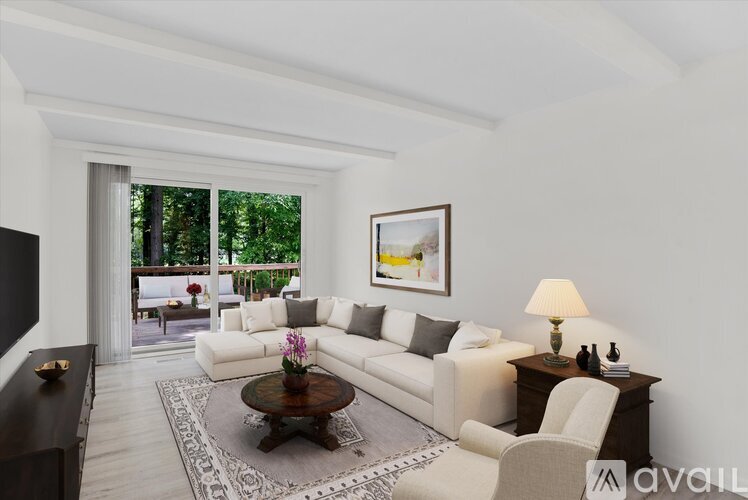 A living room with a white couch, a coffee table, and a painting on the wall.