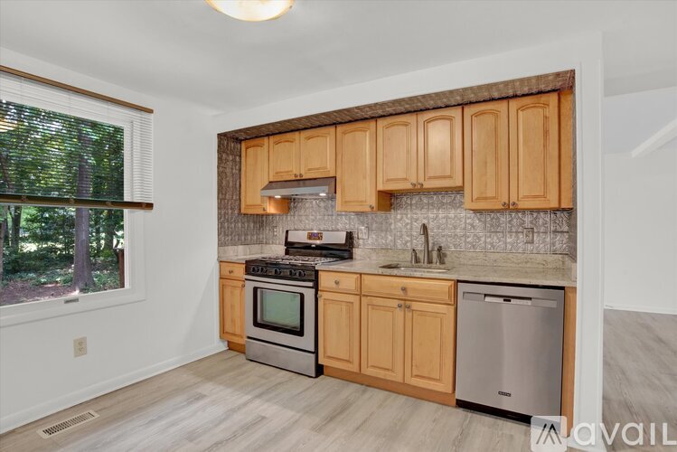 A kitchen with wooden cabinets and a stainless steel dishwasher.