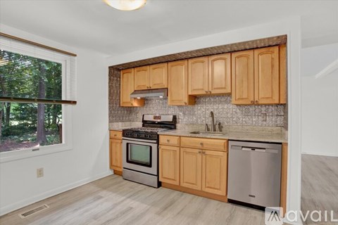 A kitchen with wooden cabinets and a stainless steel dishwasher.