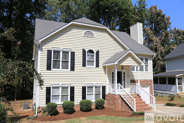 A house with a white front porch and black shutters is for sale.