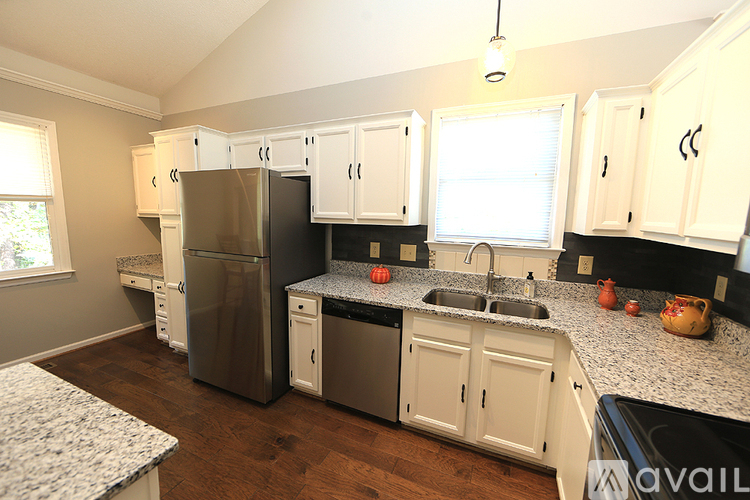 A kitchen with white cabinets and a granite countertop.