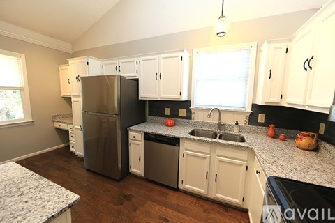 A kitchen with white cabinets and a granite countertop.