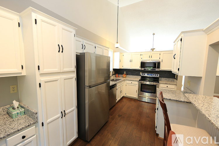 A kitchen with white cabinets and stainless steel appliances.