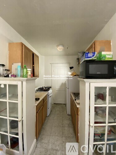 A kitchen with white appliances and wooden cabinets.
