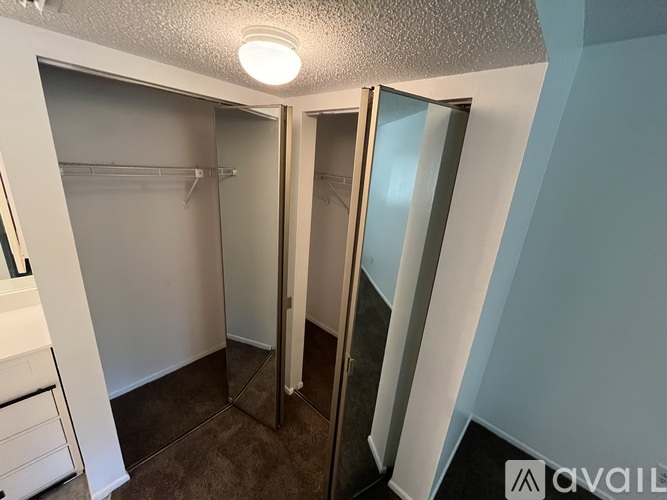 A small, empty bedroom with a walk-in closet.