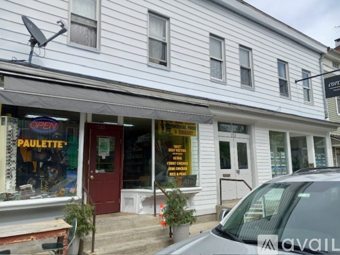 A white building with a red door and a sign that says "PAULETTE" on it.