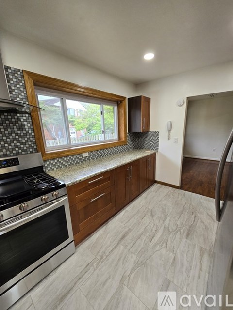A kitchen with a stove top oven and a window.