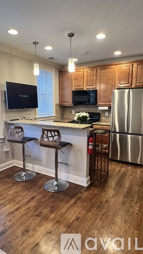 A kitchen with wooden cabinets and a stainless steel refrigerator.