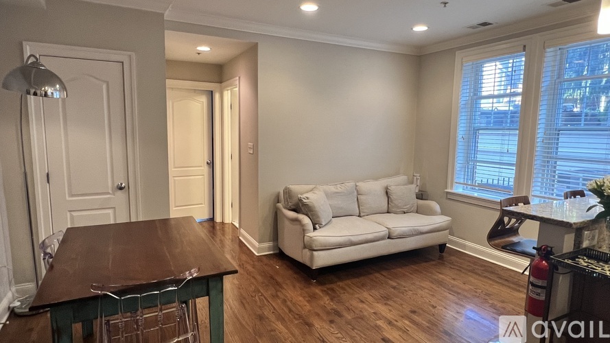 A living room with a white couch and a wooden table.