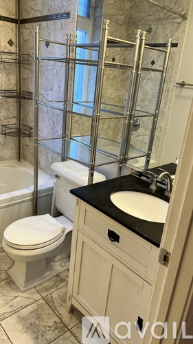 A bathroom with a toilet, sink, and a walk-in shower.