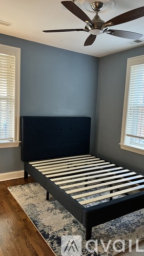 A bedroom with a bed, a ceiling fan, and a rug.