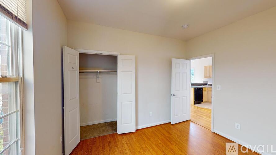 A room with a white door and a window with blinds.