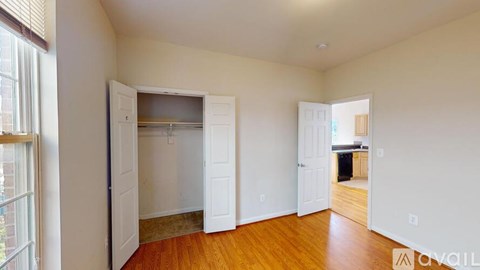 A room with a white door and a window with blinds.