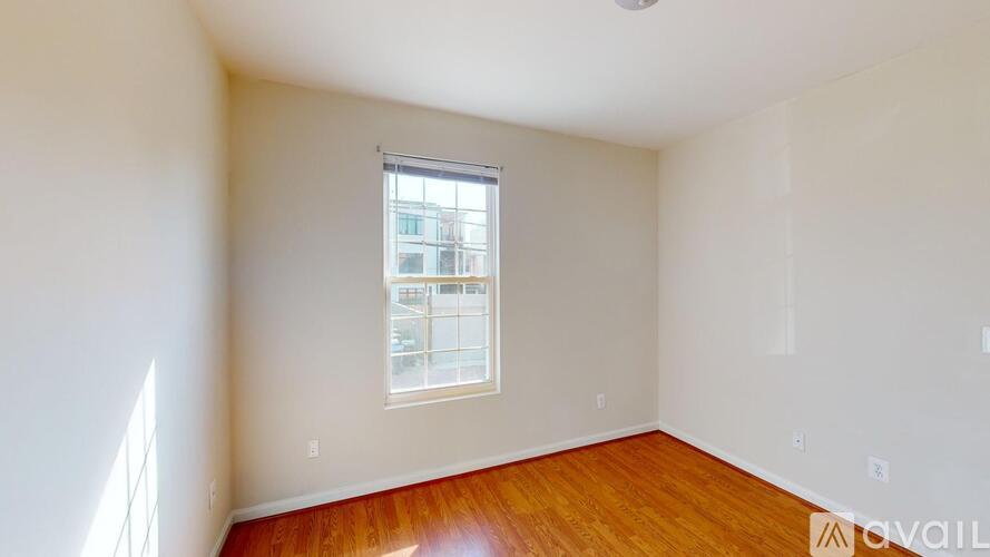 A room with a window and wooden flooring is available for rent.