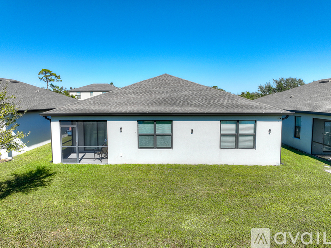 A house with a white exterior and a grey roof is available for rent.