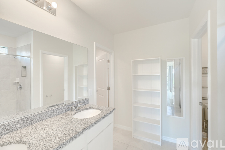 A bathroom with a granite countertop and white cabinets.