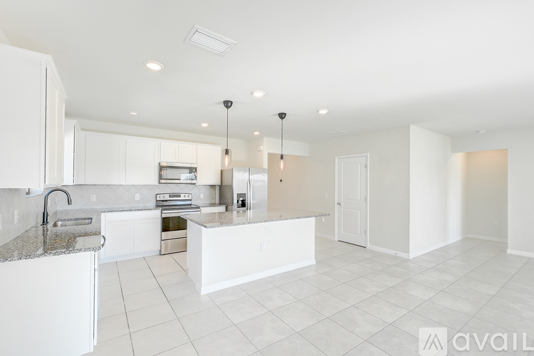 A modern kitchen with white cabinets and a granite countertop.
