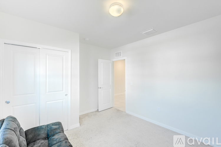 A living room with a grey couch and two doors.