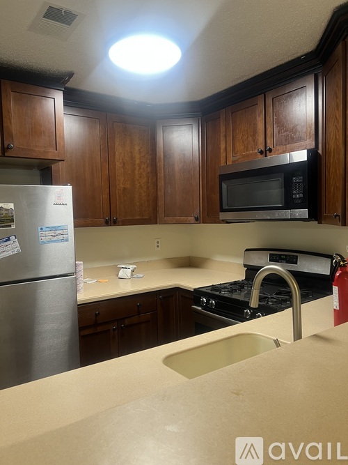 A kitchen with a stainless steel refrigerator, microwave, and stove.
