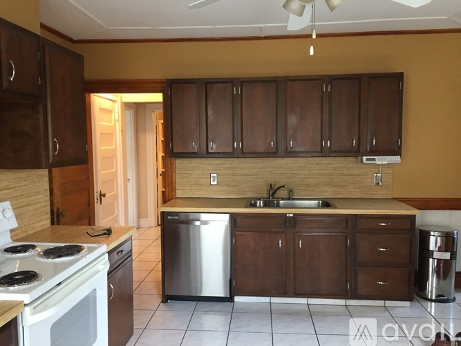 A kitchen with brown cabinets and a stainless steel dishwasher.