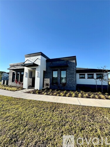 A modern house with a white and grey exterior and a black roof.