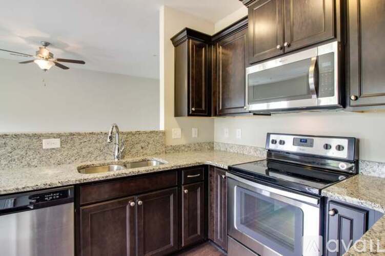 A kitchen with dark brown cabinets and stainless steel appliances.