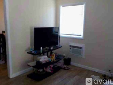 A living room with a television and a window.