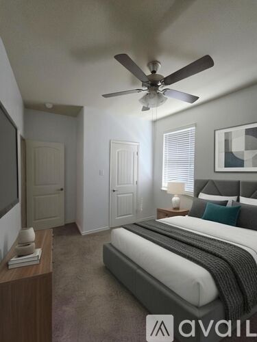 A bedroom with a large bed and a ceiling fan.