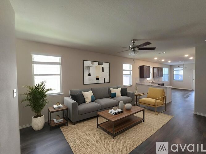A living room with a grey couch, a yellow chair, and a plant.