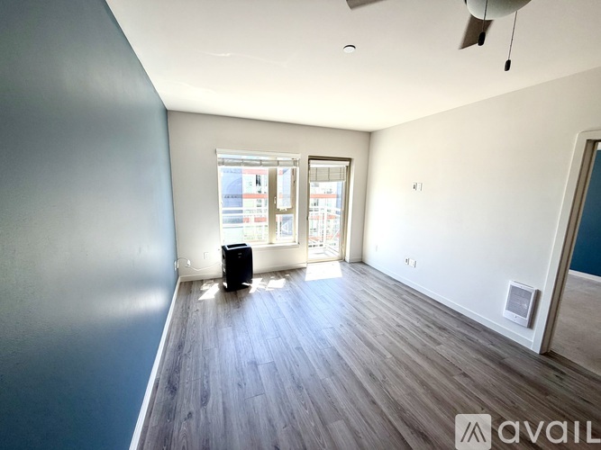 A room with a large window and a wooden floor.