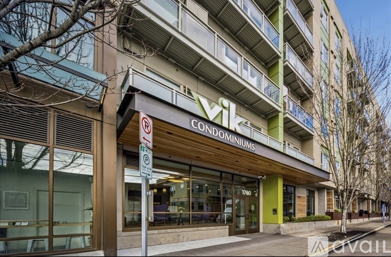 A building with a green and white facade has a sign that reads "vik condominiums.".